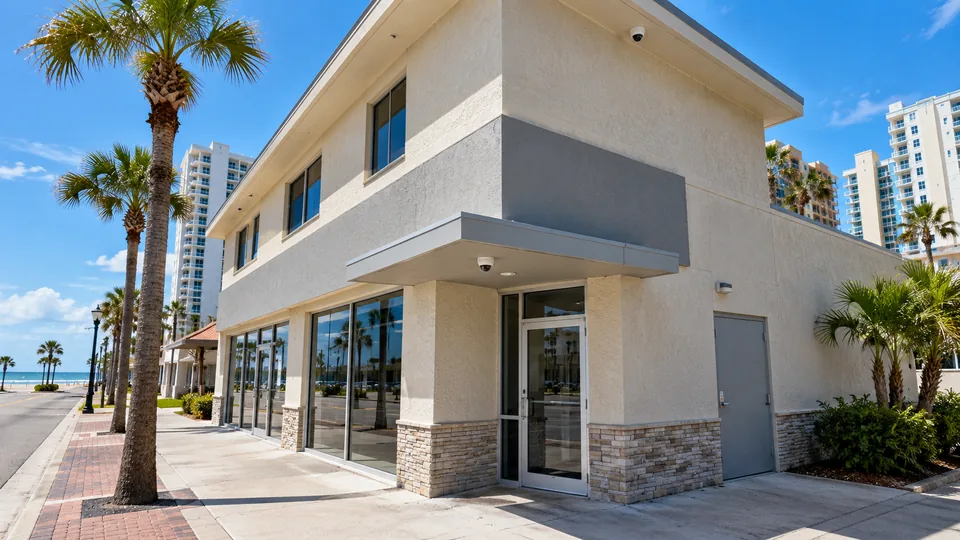 Mixed-tenant commercial building with storefront, office entrance and delivery door covered by flush-mounted cameras