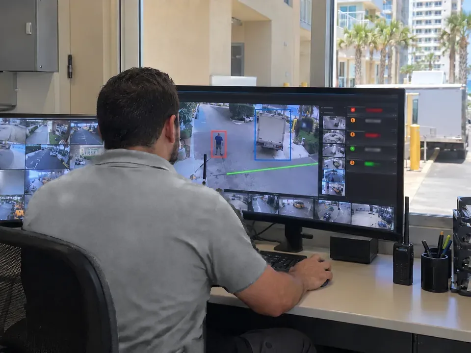 Data Pro technician reviewing live camera views with person and vehicle detections and a virtual line across a coastal property entrance.